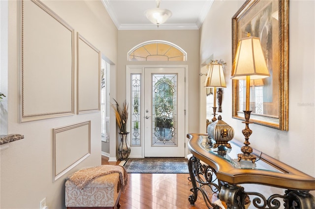 foyer with baseboards, hardwood / wood-style flooring, and crown molding