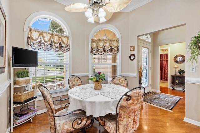 dining space with crown molding, baseboards, and wood finished floors