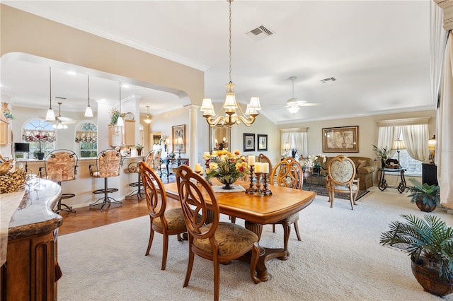 dining room featuring visible vents, arched walkways, ornamental molding, ornate columns, and ceiling fan with notable chandelier