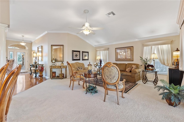 carpeted living room with lofted ceiling, ceiling fan, visible vents, ornamental molding, and ornate columns