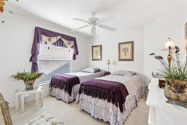 bedroom featuring light carpet, ceiling fan, and baseboards