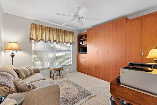 living area with carpet and a ceiling fan