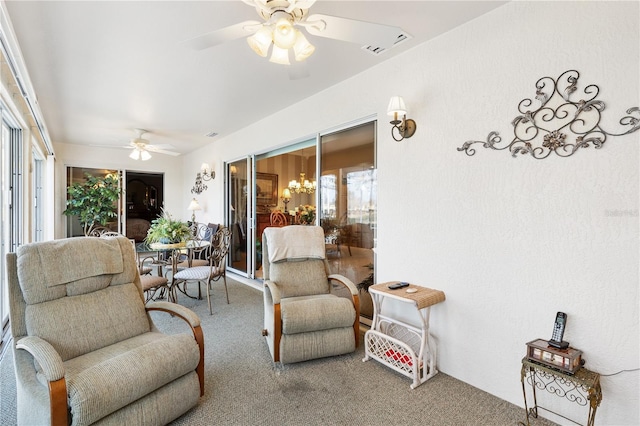 sunroom / solarium featuring ceiling fan with notable chandelier