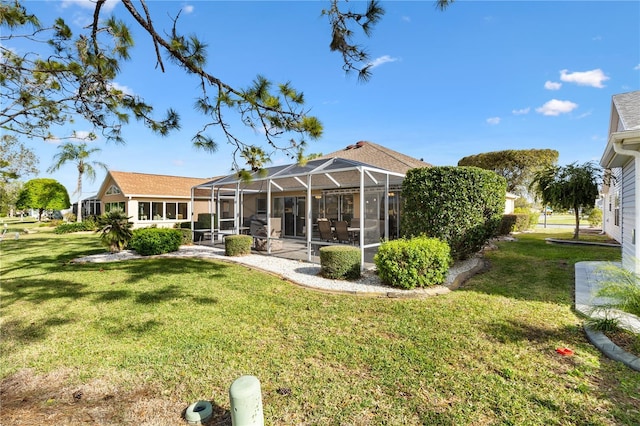 back of property featuring glass enclosure and a lawn