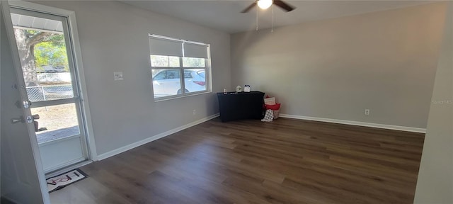 spare room with dark wood-style floors, ceiling fan, and baseboards