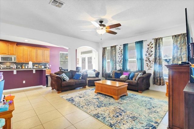 living area featuring light tile patterned floors, visible vents, and a wealth of natural light