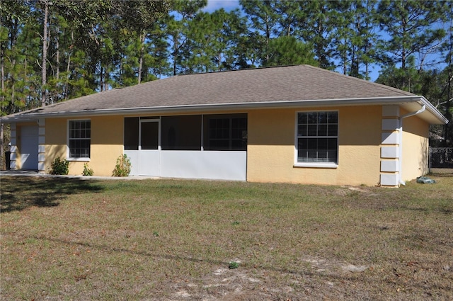 view of front of property featuring roof with shingles, a front yard, and stucco siding