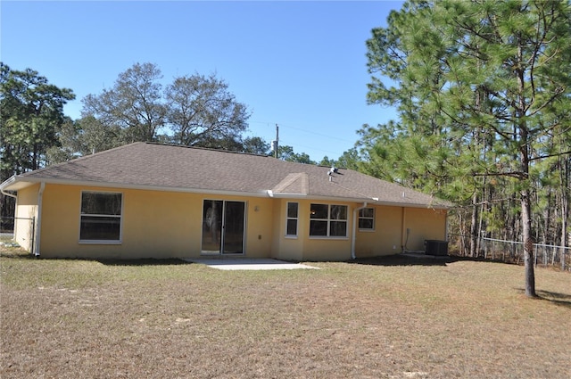 back of house featuring fence, a yard, roof with shingles, stucco siding, and a patio area