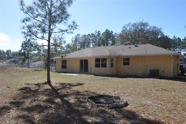 back of house featuring a yard, fence, and stucco siding