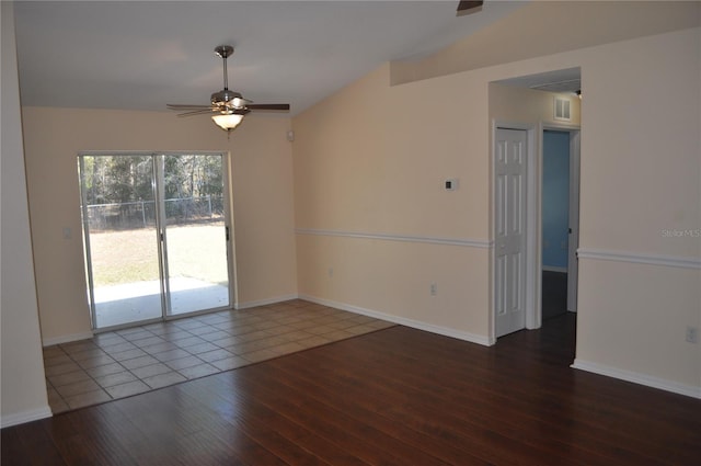 empty room featuring dark wood-style flooring, visible vents, vaulted ceiling, ceiling fan, and baseboards