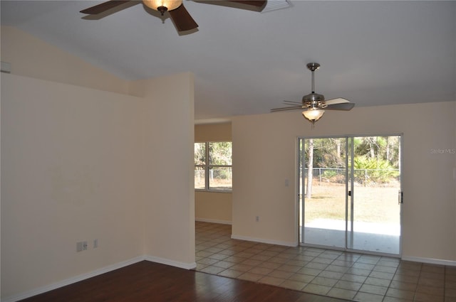 empty room featuring a ceiling fan, vaulted ceiling, light wood-style flooring, and baseboards