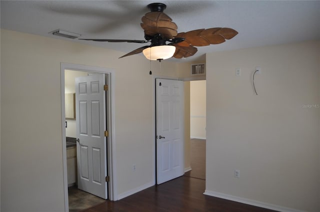 unfurnished bedroom with dark wood-style floors, visible vents, and baseboards