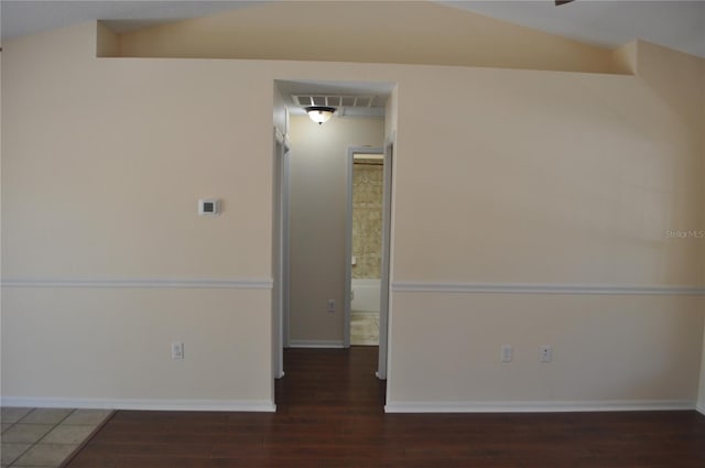 unfurnished room featuring lofted ceiling, dark wood-style floors, visible vents, and baseboards