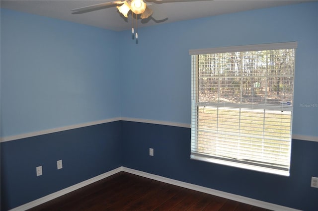 empty room with a ceiling fan, baseboards, and wood finished floors