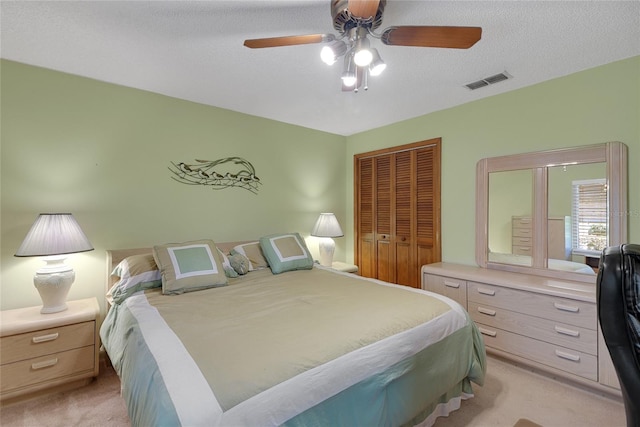 12338 S Putney Ct, Leesburg, FL 34788 - bedroom featuring a closet, light colored carpet, visible vents, a ceiling fan, and a textured ceiling