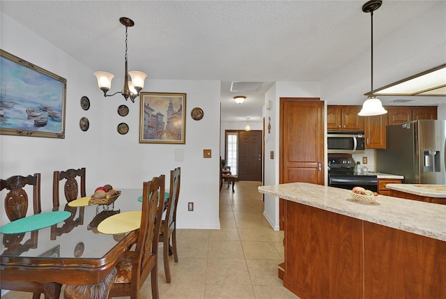 12338 S Putney Ct, Leesburg, FL 34788 - kitchen featuring light tile patterned floors, a textured ceiling, appliances with stainless steel finishes, brown cabinets, and decorative light fixtures