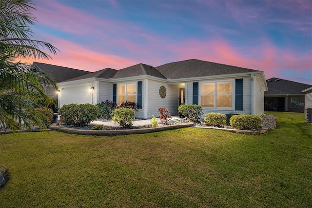 ranch-style home with a garage, a front yard, and cooling unit