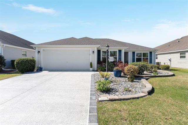 single story home with an attached garage, a shingled roof, a front lawn, and concrete driveway