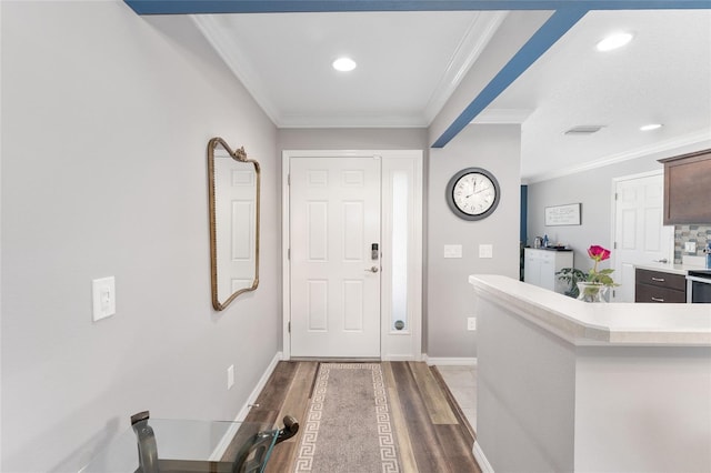 entrance foyer with ornamental molding, wood finished floors, visible vents, and baseboards