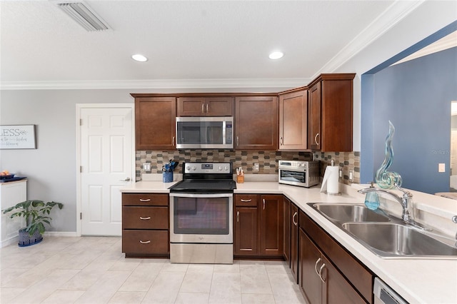 kitchen featuring light countertops, appliances with stainless steel finishes, a sink, and visible vents