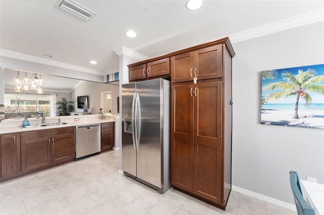 kitchen featuring visible vents, appliances with stainless steel finishes, light countertops, crown molding, and a sink