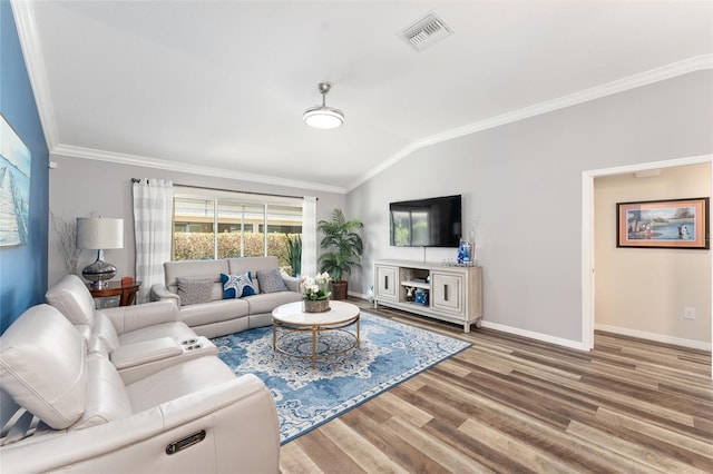 living area featuring visible vents, vaulted ceiling, wood finished floors, and ornamental molding