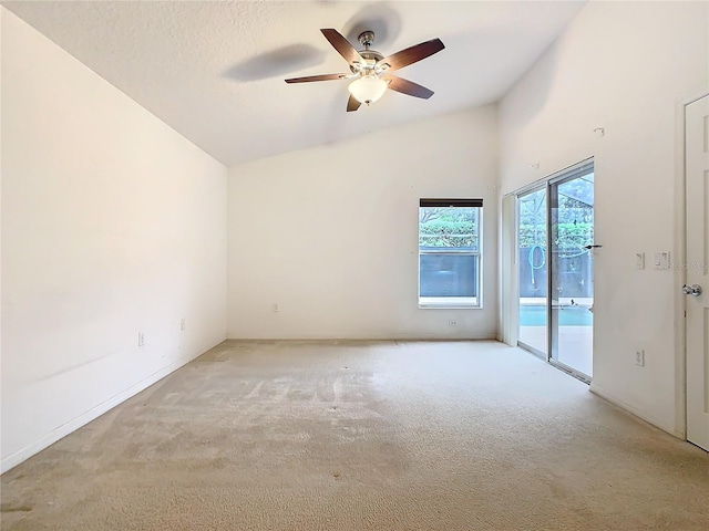 unfurnished room featuring ceiling fan, vaulted ceiling, a textured ceiling, and light colored carpet