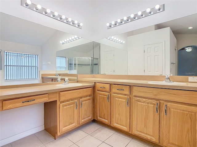 bathroom with double vanity, a sink, a shower stall, and tile patterned floors