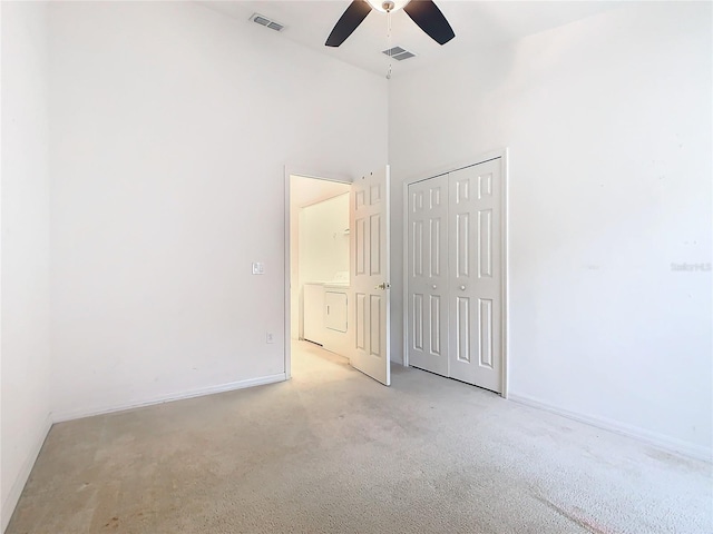 unfurnished bedroom featuring a closet, visible vents, light carpet, and baseboards