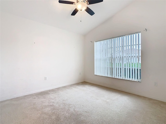 empty room with carpet floors, vaulted ceiling, baseboards, and ceiling fan