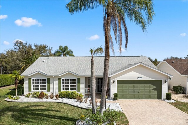 25274 Lost Oak Cir, Leesburg, FL 34748 - ranch-style home with a garage, roof with shingles, decorative driveway, and a front yard