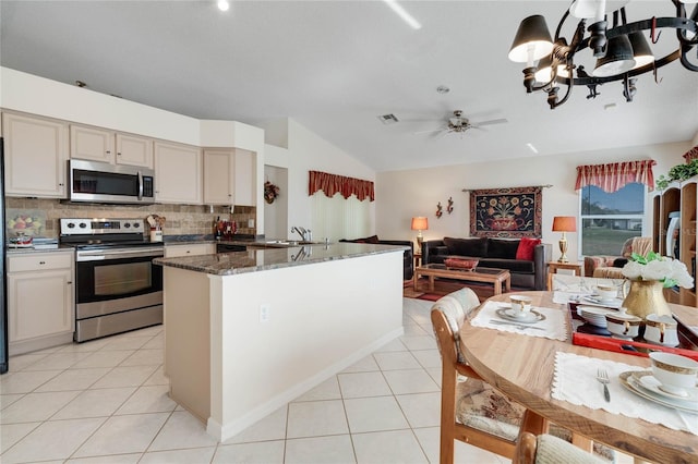 25274 Lost Oak Cir, Leesburg, FL 34748 - kitchen featuring open floor plan, appliances with stainless steel finishes, dark stone countertops, and light tile patterned floors