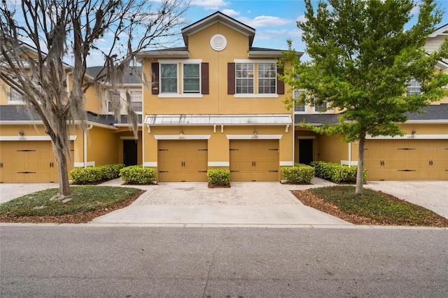 view of property with driveway, an attached garage, and stucco siding