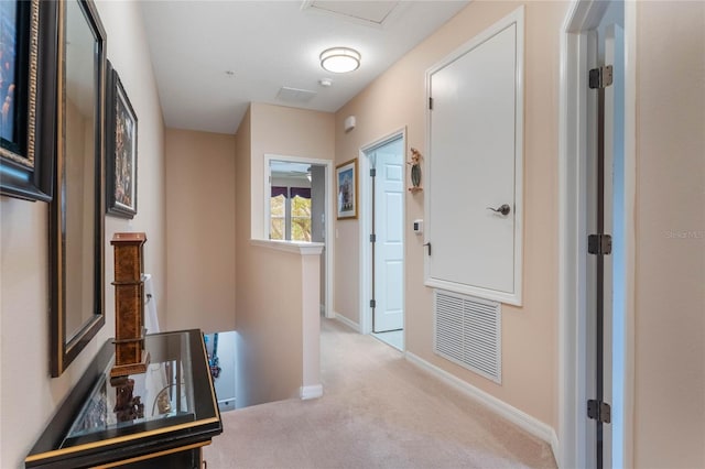 corridor featuring light colored carpet, baseboards, visible vents, and an upstairs landing