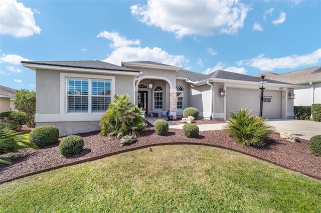 view of front facade featuring concrete driveway, a front lawn, an attached garage, and stucco siding