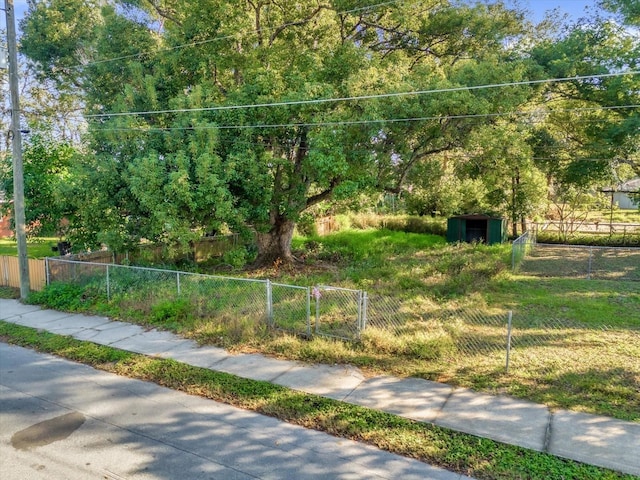 view of community with a fenced front yard and an outbuilding