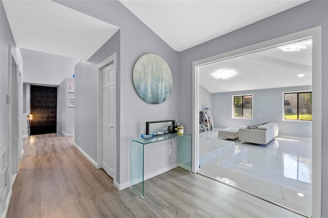 corridor featuring baseboards and wood finished floors