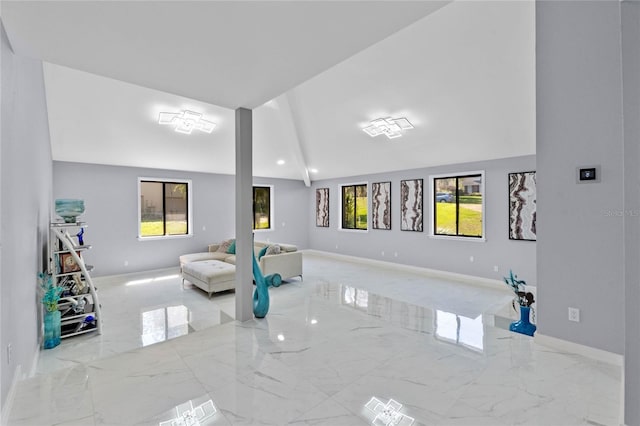 living area with baseboards, lofted ceiling, and marble finish floor