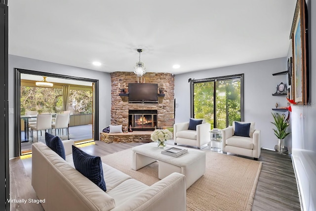 living room featuring recessed lighting, a fireplace, and wood finished floors