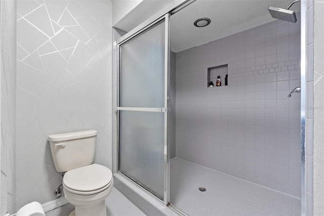 full bath with a shower stall, toilet, and tile walls