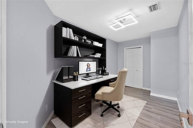 office space with light wood-style floors, baseboards, and visible vents