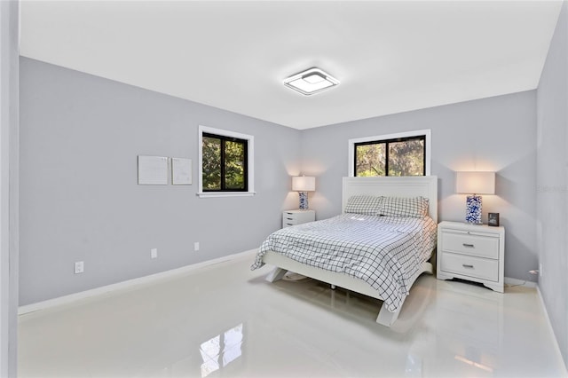 bedroom featuring baseboards and multiple windows