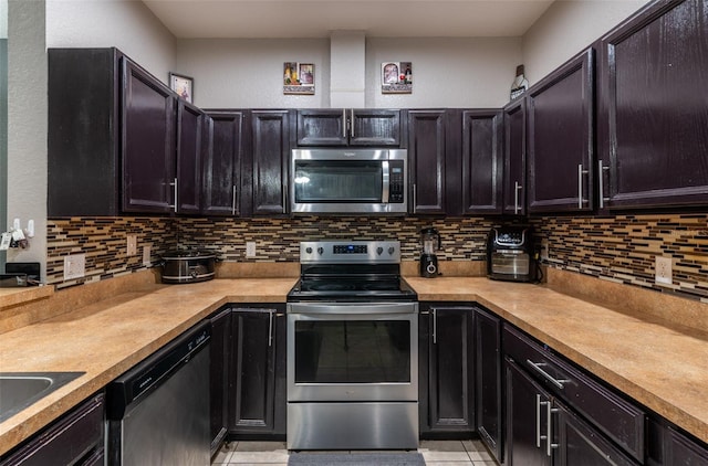 kitchen featuring stainless steel appliances, light countertops, backsplash, and light tile patterned floors