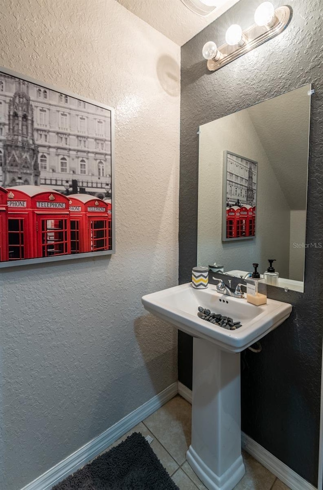 bathroom with a textured wall and tile patterned floors