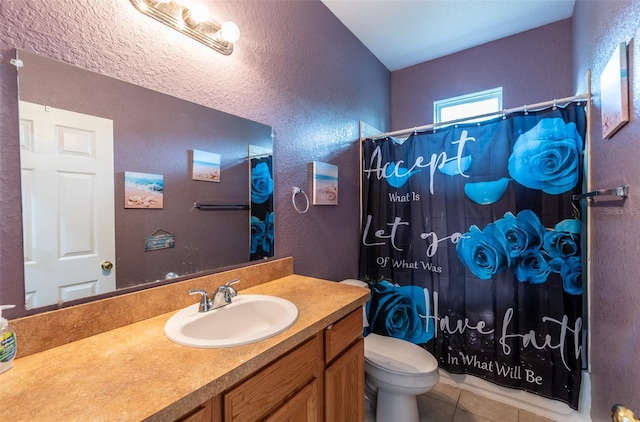 bathroom featuring curtained shower, a textured wall, toilet, vanity, and tile patterned flooring