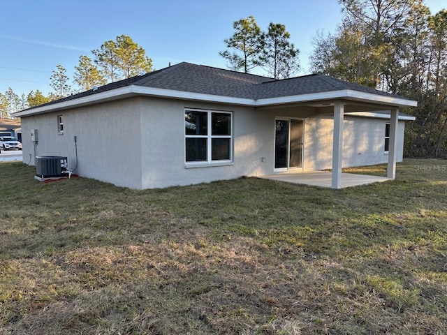 back of house featuring a patio area, a lawn, and central air condition unit