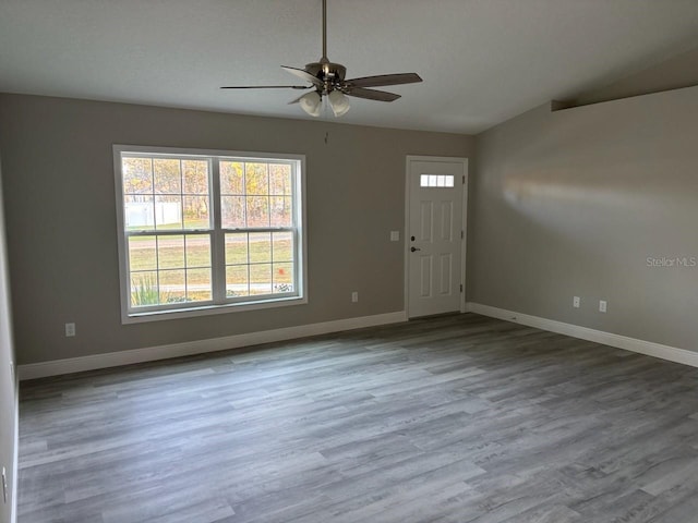 foyer entrance with lofted ceiling, wood finished floors, a ceiling fan, and baseboards