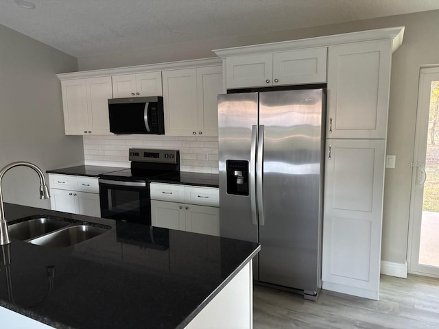 kitchen with dark countertops, white cabinets, and stainless steel appliances