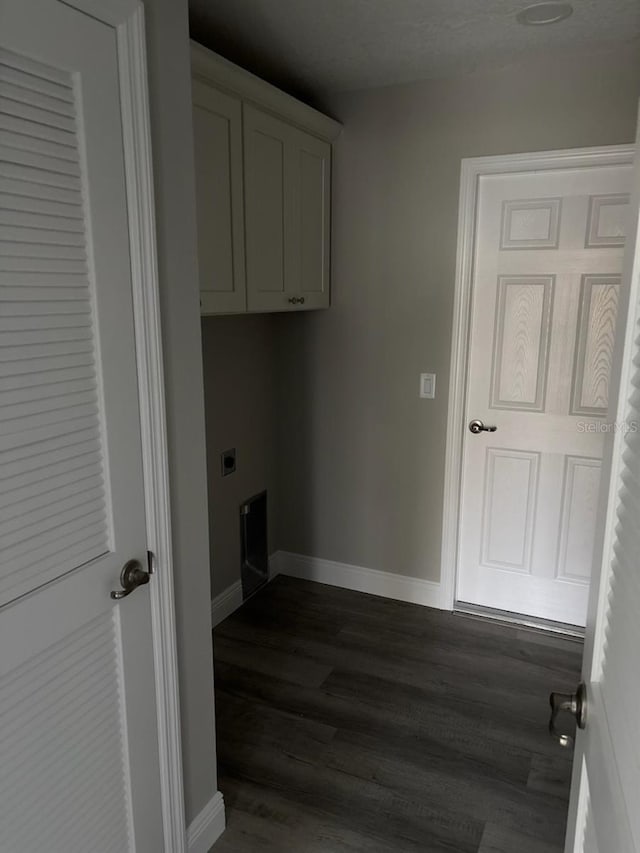 laundry area featuring cabinet space, baseboards, dark wood-style flooring, and hookup for an electric dryer