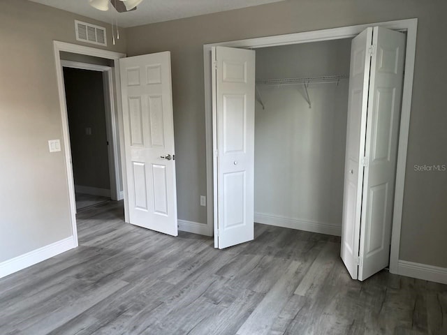 unfurnished bedroom with light wood-style flooring, a closet, visible vents, and baseboards